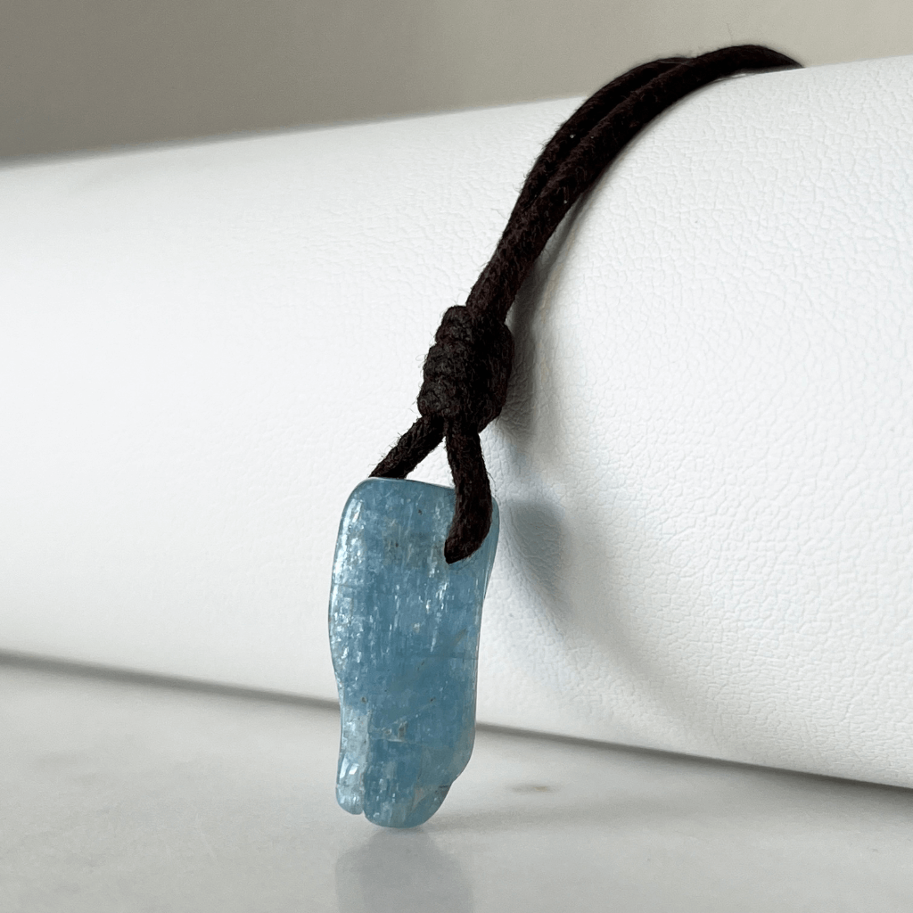 Unique Raw Aquamarine Stick Pendant, showcasing its elongated, natural form and serene blue hues, symbolizing tranquility and clarity - Luck Strings.
