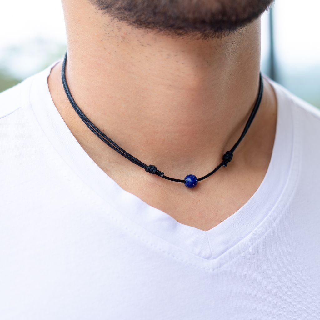 Man wearing a Luck Strings Unisex Beaded Choker, showcasing a variety of gemstones on an adjustable cord, reflecting a blend of style and diverse energies.
