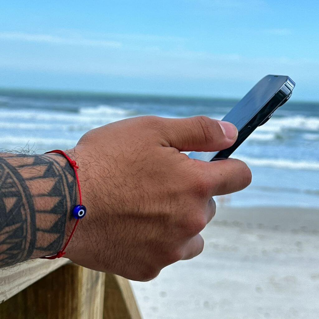 Man wearing a minimalist red cord evil eye bracelet, showcasing a subtle yet stylish protective accessory. - Luck Strings