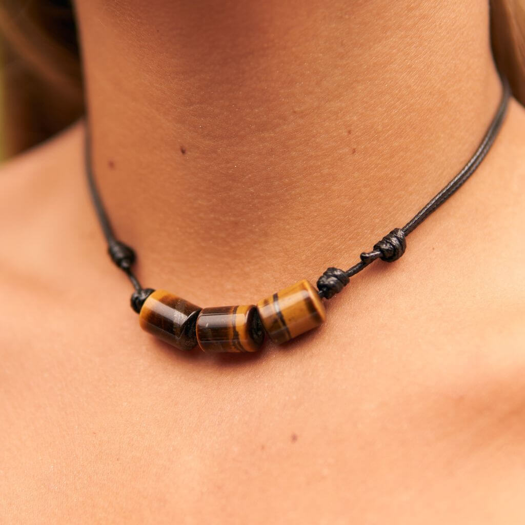 Woman wearing an elegant bohemian Tiger Eye Cylinder Necklace with adjustable waxed nylon cord, reflecting her earthy elegance and positive energy - Luck Strings