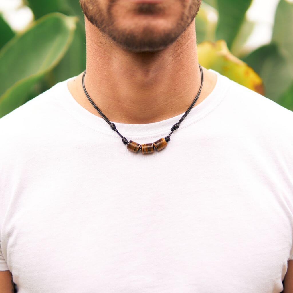 Man showcasing a Boho Tiger Eye Cylinder Necklace with waxed nylon cord, highlighting his rustic style and connection with nature - Luck Strings