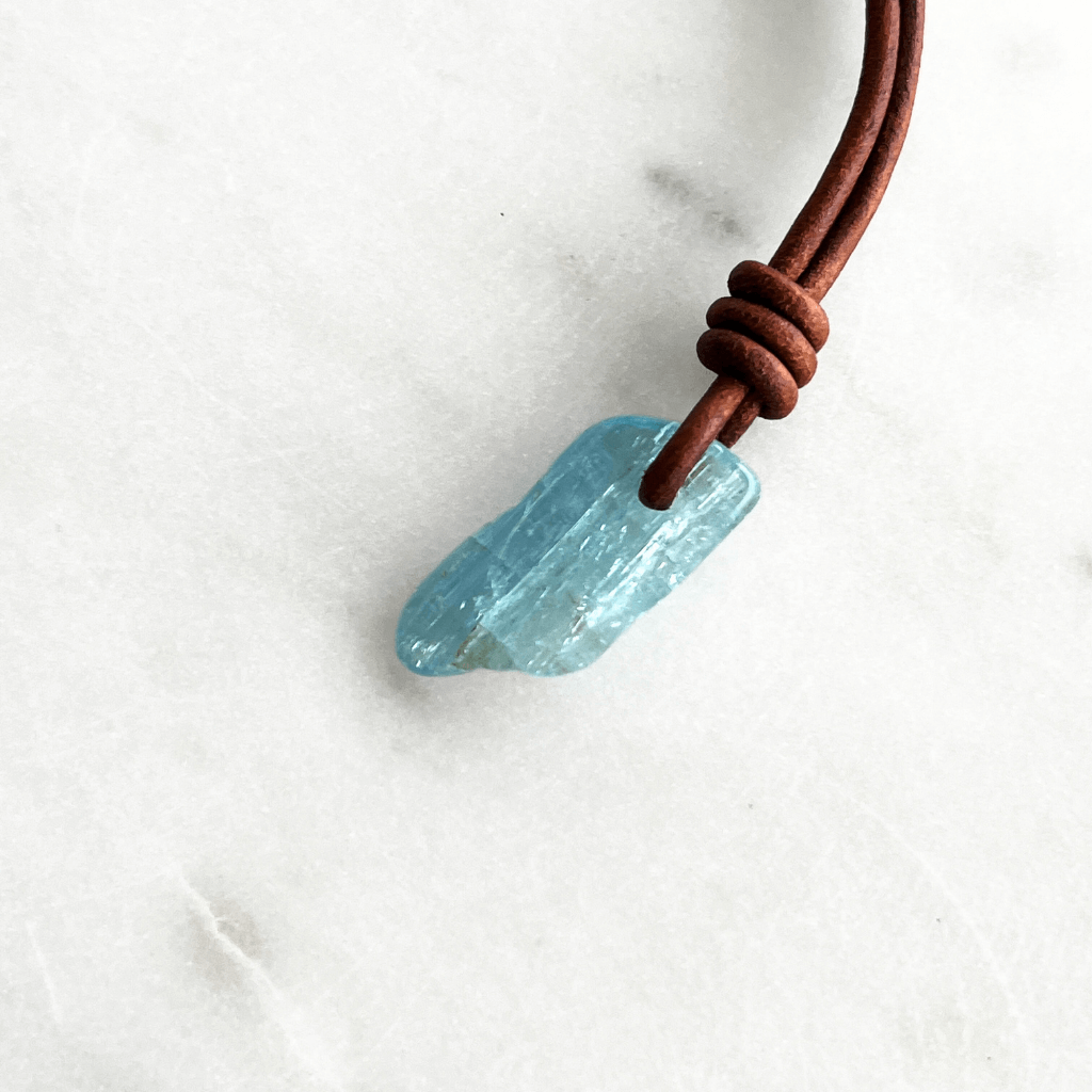 Serene Reflections: A pendant necklace showcasing a natural small aquamarine gemstone, echoing the calm and peaceful reflections of a tranquil surface.