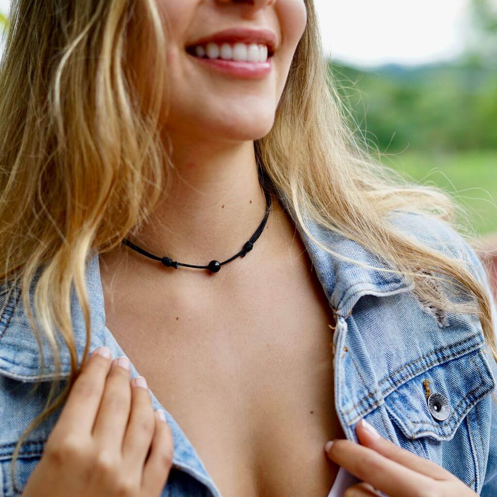 Woman adorned with a Luck Strings Unisex Beaded Choker, elegantly displaying the mixed gemstones on a versatile and water-resistant wax cotton cord.