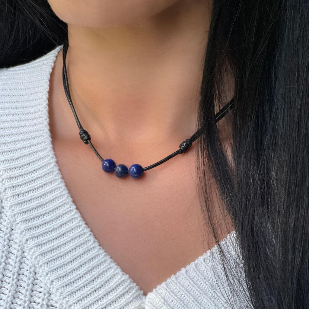 Woman showcasing an elegant Lapis Lazuli Beaded Choker, with deep blue beads complementing her sophisticated outfit - LUCK STRINGS