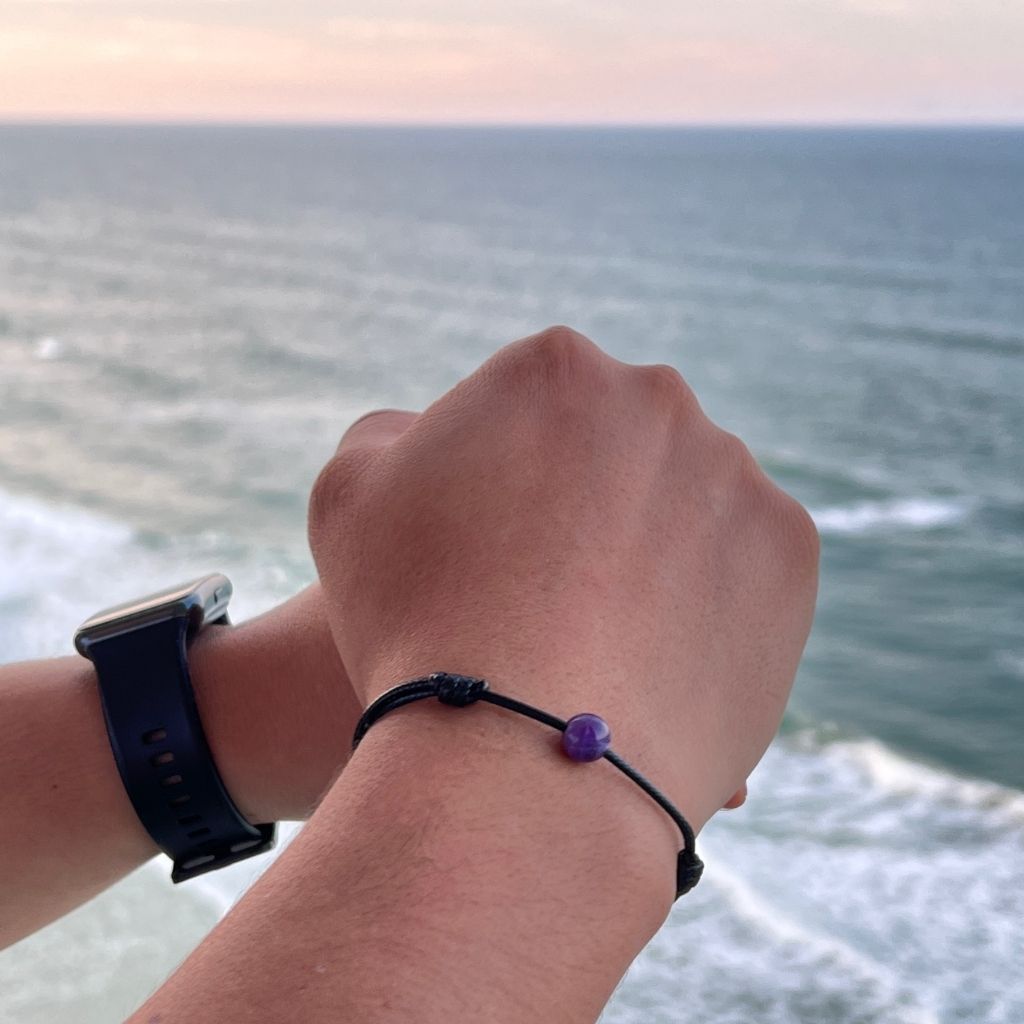 Man confidently sporting the Amethyst Beaded Bracelet, showcasing its tranquil charm and stylish poise - Luck Strings