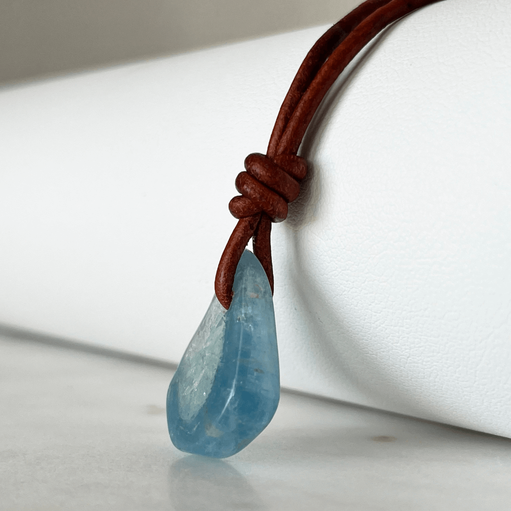 Unique one-of-a-kind raw aquamarine pendant with natural ocean-blue hues, showcasing the gemstone's unpolished beauty on a delicate cord - Luck Strings.