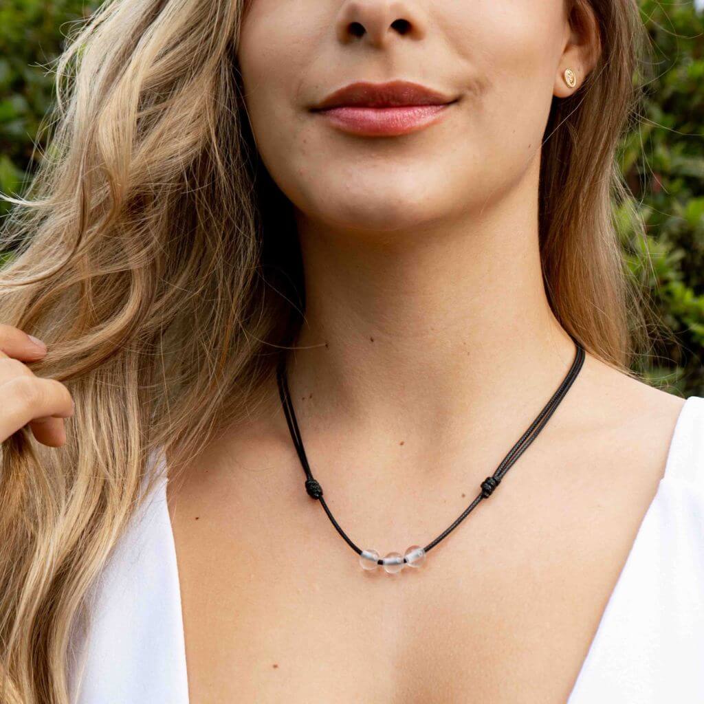 Woman gracefully wearing a Clear Quartz Beaded Choker, highlighting its luminous beads and adding a touch of refined elegance to her look - Luck Strings