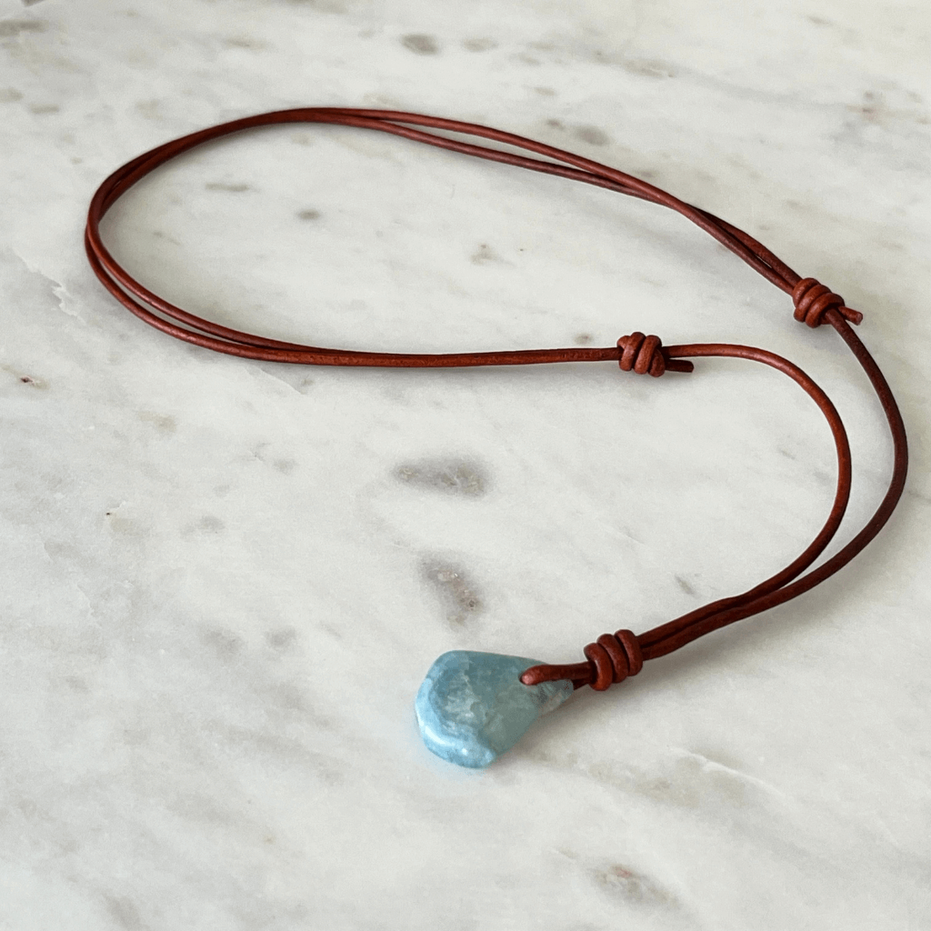 Unique one-of-a-kind raw aquamarine pendant with natural ocean-blue hues, showcasing the gemstone's unpolished beauty on a delicate cord - Luck Strings.