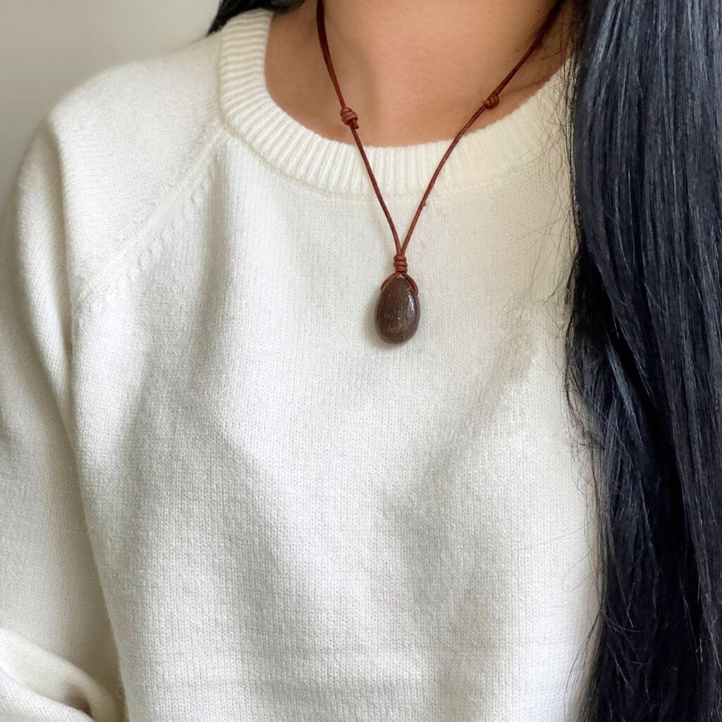Close-up of a woman wearing a Dinosaur Bone Necklace with an adjustable distressed brown leather cord - Luck Strings