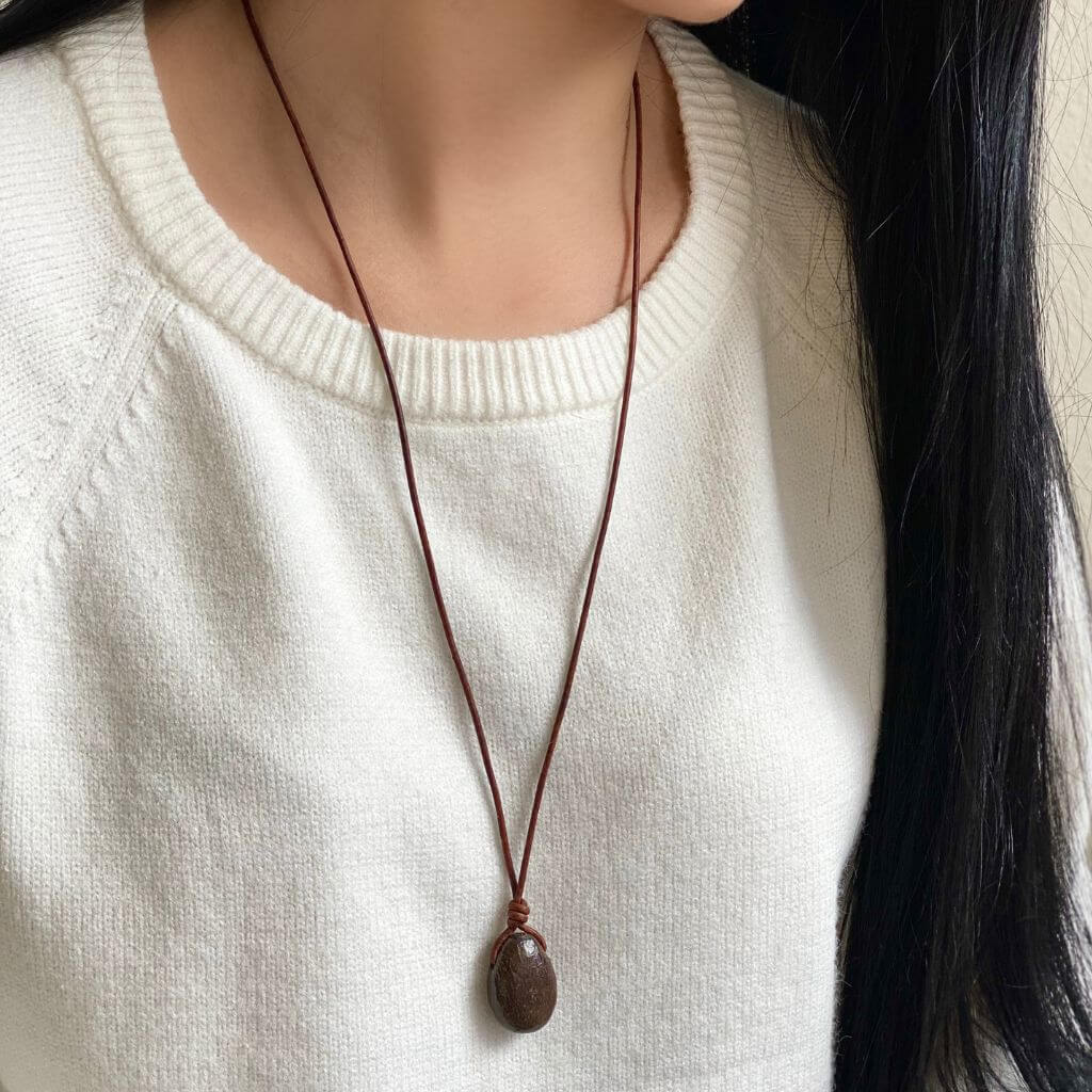 Close-up of a woman wearing a Dinosaur Bone Necklace with an adjustable distressed brown leather cord - Luck Strings