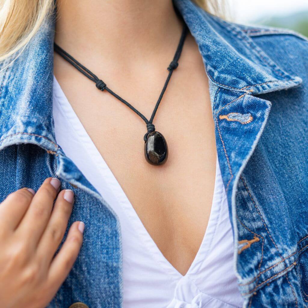 A woman elegantly wearing the Luck Strings Jet Stone Necklace, showcasing its deep black color and timeless design 