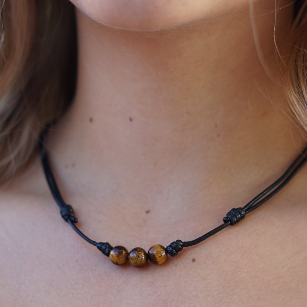 Women showcasing a Tiger Eye Choker, with the stone&#39;s distinctive golden-brown shimmer accentuating their stylish and confident look - Luck Strings