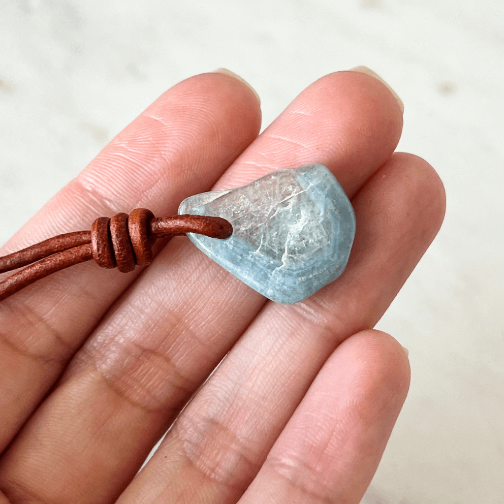 Unique one-of-a-kind raw aquamarine pendant with natural ocean-blue hues, showcasing the gemstone's unpolished beauty on a delicate cord - Luck Strings.