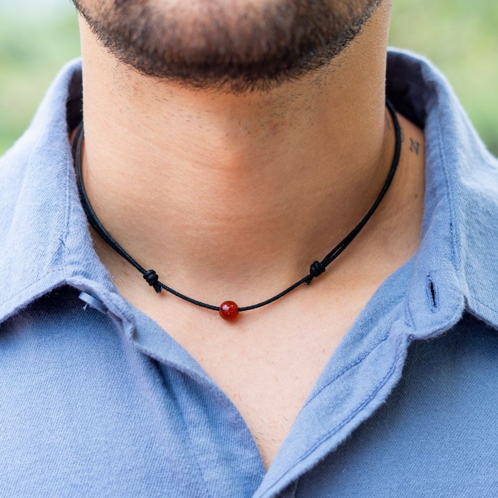 Man wearing a Luck Strings Unisex Beaded Choker, showcasing a variety of gemstones on an adjustable cord, reflecting a blend of style and diverse energies.