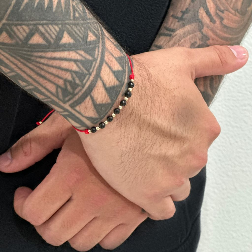 Man wearing a Black Tourmaline & 14K Gold Red Bracelet, showcasing the elegant blend of the protective black stone and luxurious gold accents - Luck Strings.