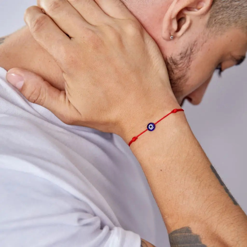 Man wearing a minimalist red cord evil eye bracelet, showcasing a subtle yet stylish protective accessor. - Luck Strings