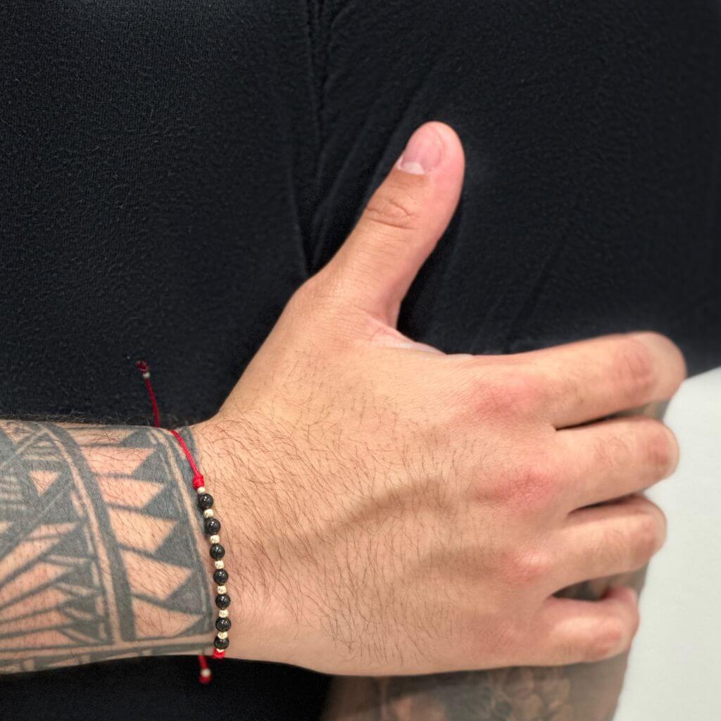 Man wearing a Black Tourmaline & 14K Gold Red Bracelet, showcasing the elegant blend of the protective black stone and luxurious gold accents - Luck Strings.