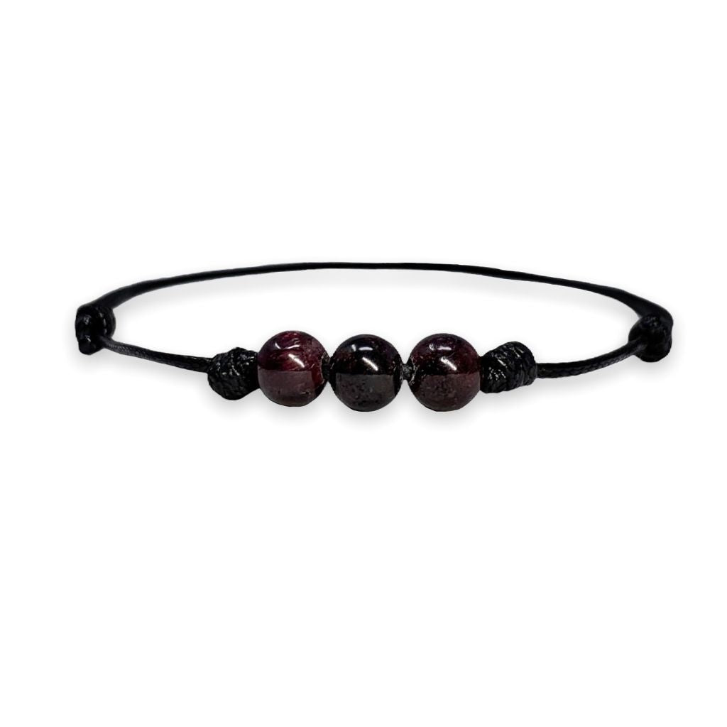 Luck Strings garnet beaded choker on a white surface, featuring an adjustable black waxed nylon cord.