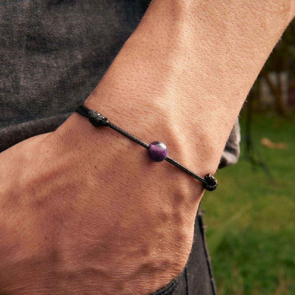 Man confidently sporting the Amethyst Beaded Bracelet, showcasing its tranquil charm and stylish poise - Luck Strings