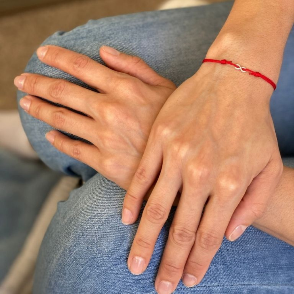 Woman gracefully wearing the Sterling Silver Red String Infinity Bracelet, symbolizing eternal elegance and protection - Luck Strings
