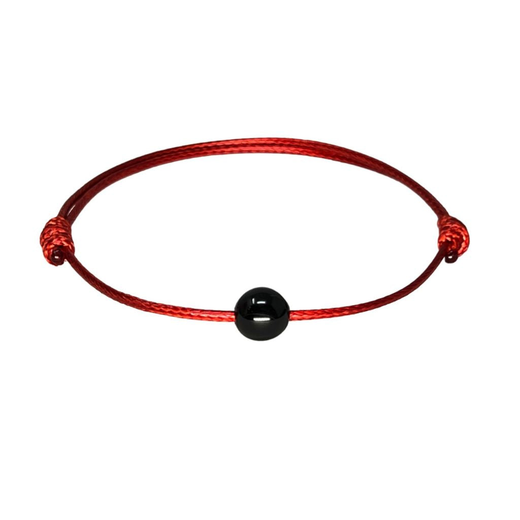 Luck Strings -A woman's wrist adorned with the Protection Black Tourmaline Red String Adjustable Bracelet 
