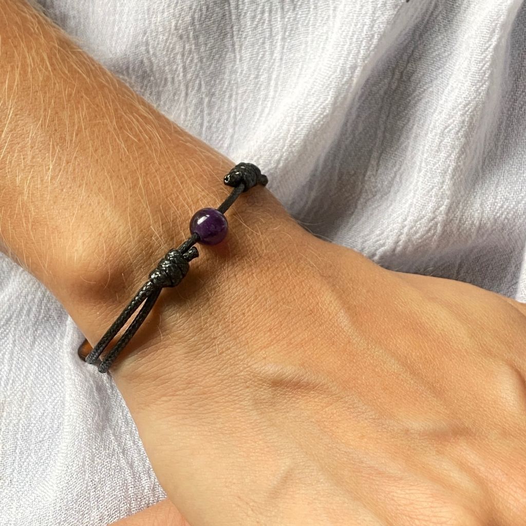 Woman gracefully wearing the Amethyst Beaded Bracelet, reflecting its serene beauty and calming elegance - Luck Strings.
